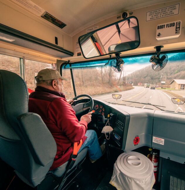 Driver in red jacket inside bus
